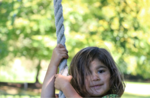 Child outdoors on a rope swing